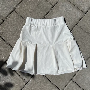 Vit tenniskjol  - Supersöt vit tenniskjol. Använd en gång i musikvideo. Strl. 36.