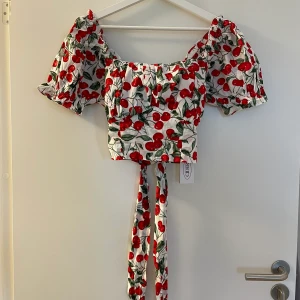 HELT NY. Cider blus körsbär - Superfin blus med körsbärsmotiv från cider. Bandet knyts till en rosett baktill.🍒🎀   !!Helt ny!! Nypris: 250kr  Var tyvärr lite för stor för mig men köpte en mindre som jag älskar! Supersöt på!!