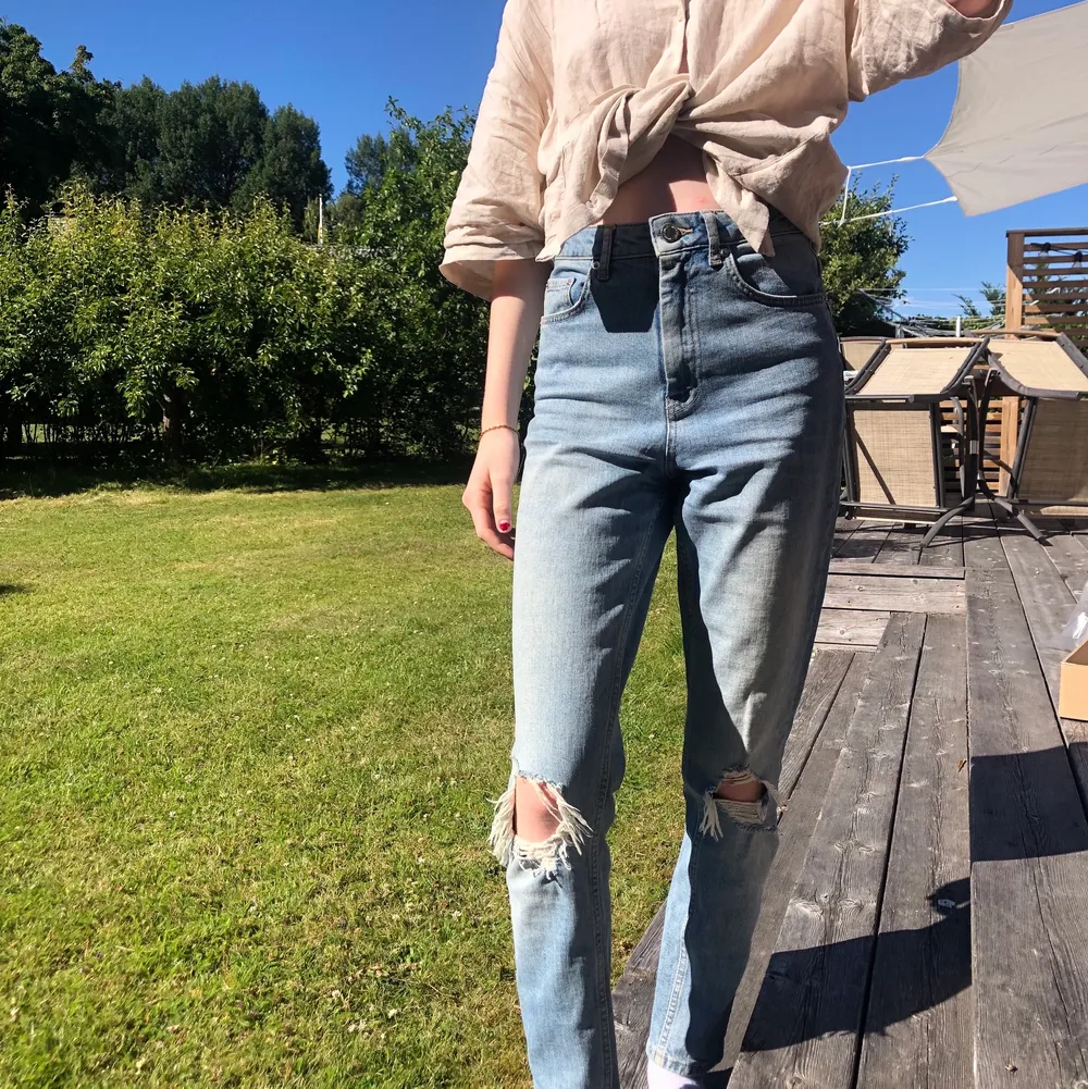 Säljer dessa mom-jeans från Gina Tricot, med hål som detaljer på knäna. De är i modellen LEAH💙 Endast använda ungefär 10 gånger, så väldigt bra skick! Säljer då de inte passar mig längre. Frakt kan variera beroende på pris. (Tryck INTE på köp nu). Jeans & Byxor.