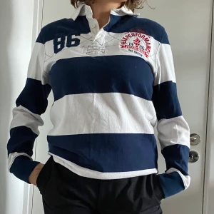 Peakperformance tröja  - En randig tröja i blå och vitt med krage