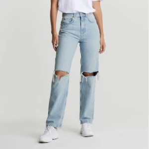 GINA BYXOR - Ginas 90s highwaist, Ljusblåa byxor med hål och slitninga sömmar där nere. Inga defekter förutom att sömmarna innuti blivigt lite rosa, absolut inget som syns på utsidan. NYPRIS 599kr, hör av er vis frågor, pris kan diskuteras.