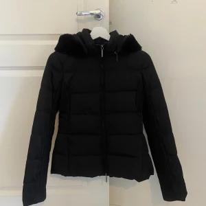 Dunjacka Armani Jeans - Jättefin svart vinterjacka i dun från Armani Jeans. Snygg luva med faux fur, luvan går även att ta av. Det står att det är storlek EU 42/US 6, jag skulle säga att det är en S. 