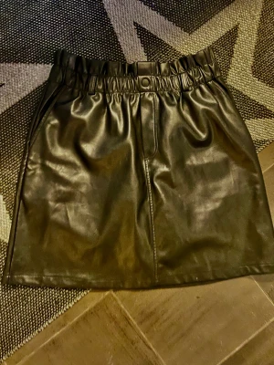 Noisy May läder kjol mattsvart L - Super snygg fiskstim kjol/ läder i natt svart. Noisy May stl L passar M även, snygg som midjekjol. 