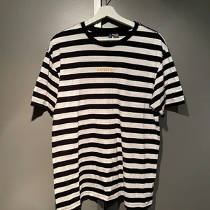Randig t-shirt - Randig t-shirt med gult ”SATISFIED” broderi. Bra skick och knappt använd.