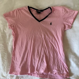 Ljusrosa T-shirt från Ralph Lauren strlM - I princip ny ljusrosa / rosa Ralph Lauren t-shirt med mörkblått märke och mörkblå v-ringad krage. Strl M, men passar även XS-S. Frakt 26kr🥰
