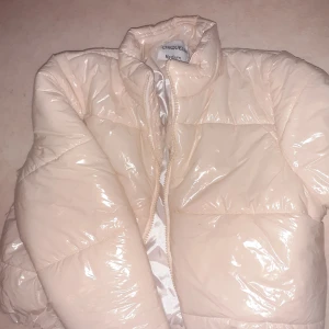 Pufferjacket  - Ljusbeige glansig pufferjacket med lappen kvar. Storlek M från Chiquelle Bilden visar färgen bra, aldrig använd.