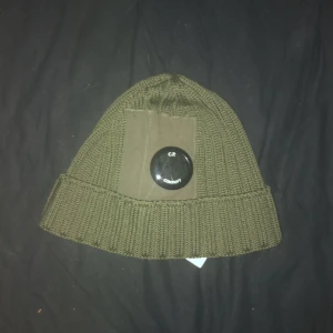 C.P Company mössa (mörk grön) - Säljer min oanvända C.P mössa, skick 10/10, köpte den för 1300kr men säljer den för runt 800-900kr och den är äkta, man kan scanna QR koden inuti mössan ( är öppen för byten )