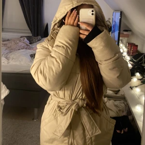 Jacka - Säljer denna superfina jacka med bälte i midjan från nakd. Köpte den här på Plick men tyvärr var den för stor för mig❣️(2&3 bild är lånad) jackan är varm och kan användas på hösten men även nu till vintern. 