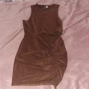 En jättesnygg glittrig klänning i strl L från H&M med ett litet hål vid midjan och snörre så att du kan ändra längden lite själv. Perfekt till nyår och fester men även till utomlandsresan 