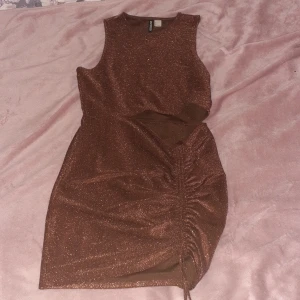 Klänning i strl L - En jättesnygg glittrig klänning i strl L från H&M med ett litet hål vid midjan och snörre så att du kan ändra längden lite själv. Perfekt till nyår och fester men även till utomlandsresan 