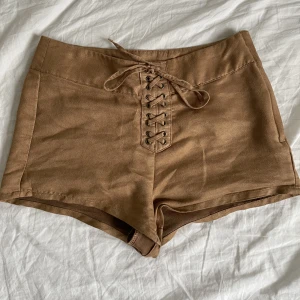 Bruna shorts  - Super coola shorts som ska efterlikna ”mocka” material Snörningen fram till kan man justera som man vill, finns dragkedja på sidan  Andvände dessa jätte mycke förr och har verkligen en ”coachella” vibe 