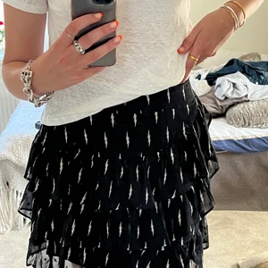 Volangkjol⚡️⚡️ - Säljer denna svarta volangkjol med blixtar på från Sofie Schnoor⚡️ Aldrig använd, i storlek S, men med resår så passar även xs/m☺️ nypris: 1300, säljer för 400 eller budgivning vid stort intresse!