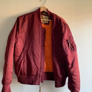 Alpha industriers Bomberjacka herr - (Säljer åt pojkvän)✨ Vinröd bomberjacka med orange foder, lätt fodrad. Använd endast ett fåtal gånger, nypris ca 1500