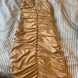 Festklänning  - Fin festklänning som sitter väldigt bra och formar sig efter kroppen i färg beige