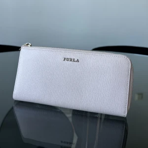 Furla Plånbok - Rosa plånbok från Furla. Köpt för ett visst antal år sedan men skulle säga att skicket är väldigt fint!! 