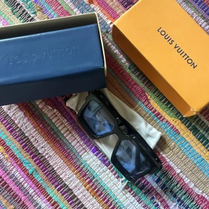 L V Millionaire Sunglasses - L V ’Millionaire’ Sunglasses Svarta med blå linser, inte sett många med denna cw. All packaging på bilden är med. Fantastiska shades men lovat mig själv att minska garderoben lite. Pm för frågor! Tar bud.  Nypris ~€600 