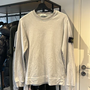 Stone Island Sweatshirt - Grå stone Island tröja i kanon skick, lite solblekt som man ser på patch annars inga flaws. Storlek S och nypris på 2300kr. Bara o skriva vid frågor eller funderingar!