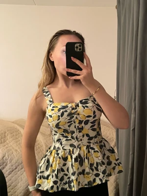 Amalfi peplum topp - Peplum topp med citron - har dragkedja och knappar Passar S/M