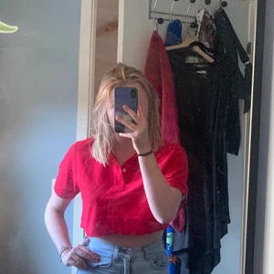 Röd croppad pikétröja  - Pikétröja från Tracker i storlek small. Man kan knäppa de 2 knapparna på framsidan. Säljes då jag inte använder den. Kan både frakta och mötas i Malmö