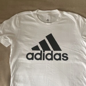 Adidas t-shirt - En vit adidas tröja som inte används alls och är i väldigt bra skick. Den är fin och cool men passar inte riktigt min stil