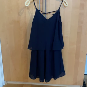 Mörkblå klänning - Mörkblå klänning från Vila i storlek S. Lätt V-ringad framtill och korsad detalj bak.