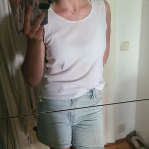 Vitt linne - Vitt linne i svalt material med skön passform och breda axelband. Storlek S - M, delad i sidan nertill.