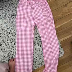 Satinbyxor - Ett par rosa-rutiga satinbyxor från Design by Si. Storlek S, lite liten i storleken. Använda en gång så de är i nyskick! 