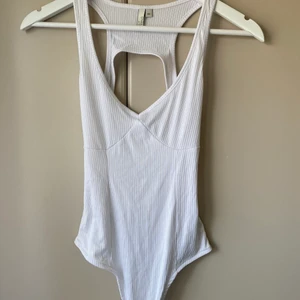 Body - Snygg och skön body från Nelly i storlek xs men funkar till S kanske M med, öppen rygg. Aldrig använd. Köpare står för frakt 