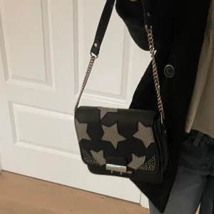 Väskor med stjärnor - Säljer denna ascoola väskan med stjärnor💕Har justerat kedjan själv så den är kortare och passar att ha på axeln. 