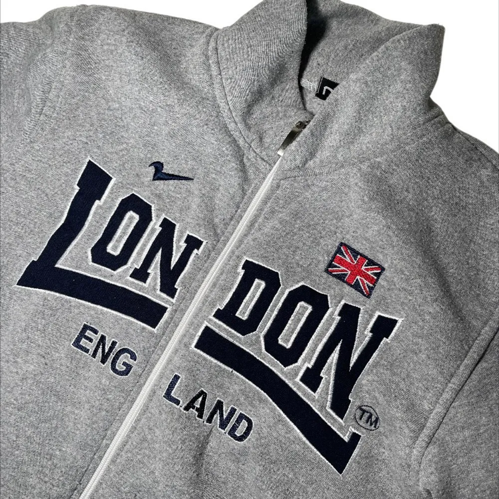 Grå zip up sweater/jacka/tjocktröja med svart tryck ”London” från märket Nas!. Jackor.