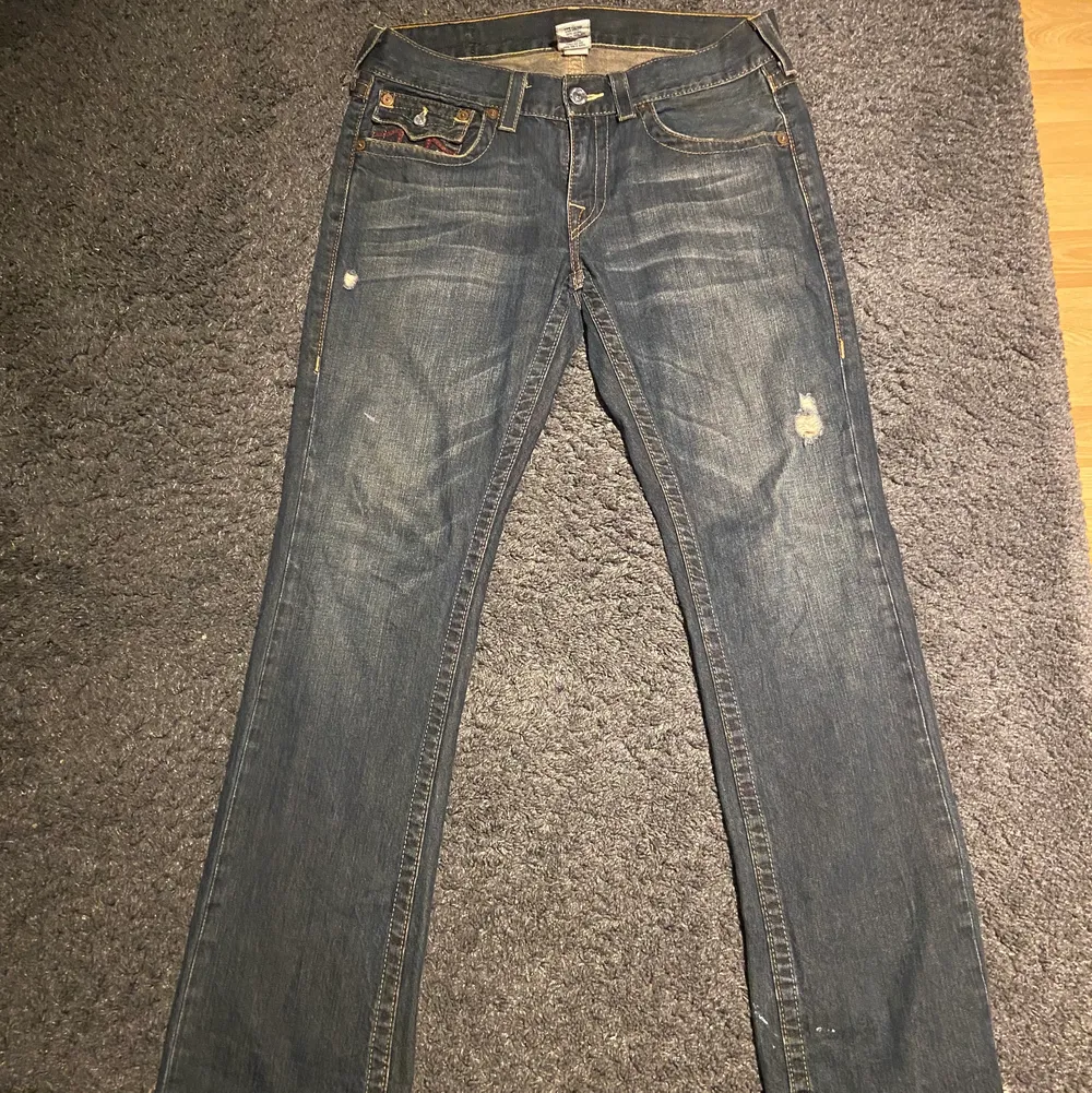 Feta true religion jeans, köpta på stöld vintage. Byxorna är straight leg och sitter perfekt. Washen är unik och det röda ovanpå passar sjukt bra. Flaw längst ned vid byxan (se sista bilden). DM för mer bilder eller ifall ni vill köpa direkt!. Jeans & Byxor.