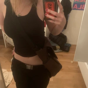 Soc axelremsväska - En rymlig brun axelremsväska med spänne på bandet. Stor och har flera fack!