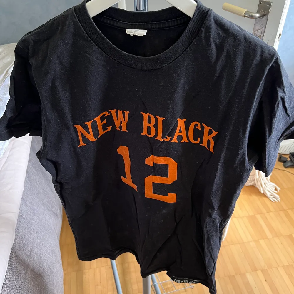 New black t shirt med orange text. Storlek medium. Mycket skönt bomulls tyg. . T-shirts.