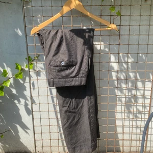Kostymbyxa st S - Ett par kostymbyxa i brunt med tunna ränder som syns på bilden, köpta second hand på herr avdelningen och står att byxan är i st 48 men jag skulle säga att dem passar som en S och är något korta i längden på mig som är 167. Fint skick!