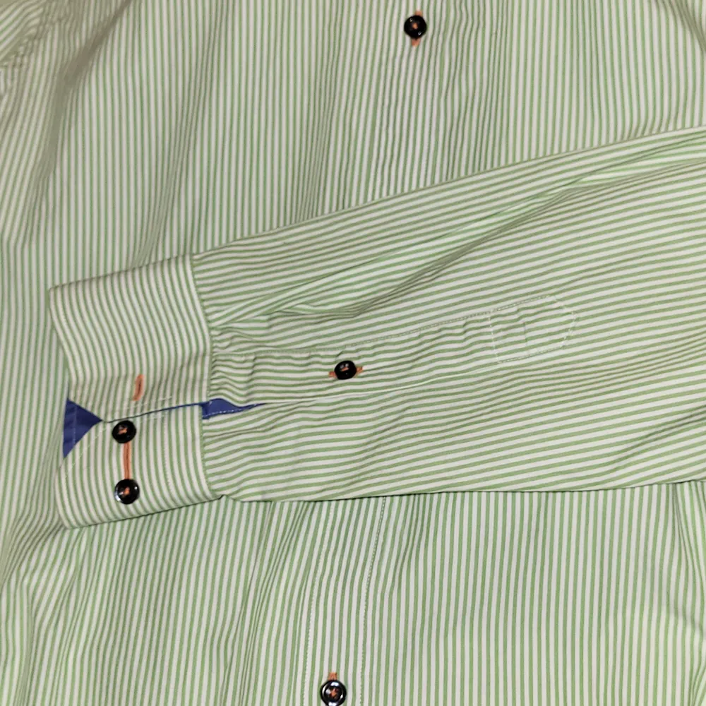 Oanvänd  Snygg grön skjorta med orange detaljer 👔  Märke: Riley  Färg: Grön med orange detalj  Storlek: M (slimfit). Skjortor.