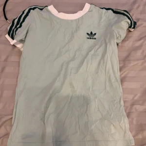 t-shirt adidas - en grön vit t-shirt från adidas, passar både tjejer och gillar, säljer då den aldrig har använts, storlek 34-36