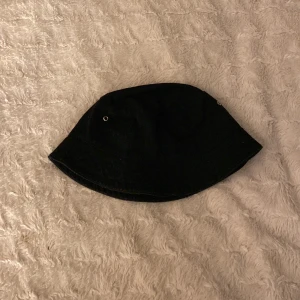 Fiskehatt - En svart fiskehatt som blivit för liten