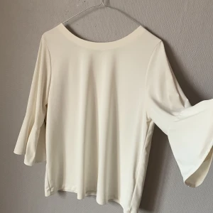 Blus från uniqlo - Blus med fint fall, trekvartslång trumpetsarm 