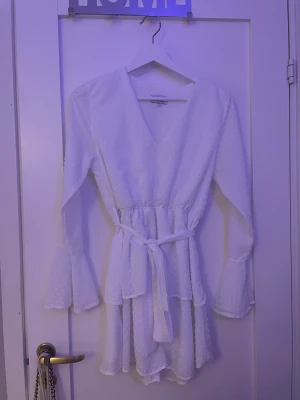 Klänning - En jätte fin vit volang klänning från madlady i storlek s knappt använd. Köparen står för frakten❤️