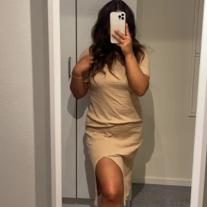 Beige klänning  - En beige klänning med slit fram i storlek M. Använt 4 gånger men är bekväm och fin