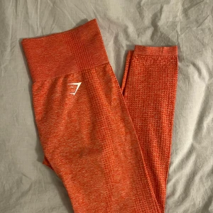 Gymshark träningstights - Säljer mina jättefina coralfärgade träningsbyxor från Gymshark. De är använda fåtal gånger och är i fint skick. Trycket bak har dock gått bort där man ser strlk men jag köpte de själv så vet att de är i strlk M. I modellen ”vital seamless 2.0 leggings”🫶🏼