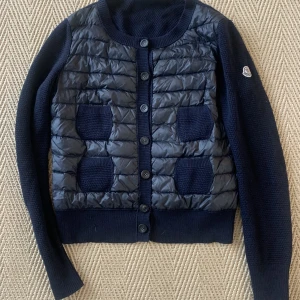 Moncler Cardigan  - Säljer min min Moncler Jacka/kofta. Jackan är då i en äldre model med knapar och är mörkblå! Den är i storlek M men passar absolut en S och förmodligen en XS.❤️