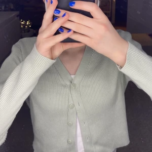 Kofta - Söt grön-beige/ljus grön lite croppad kofta från Lindex (barn). Den är i storlek 146-152cm men den passar storlek XXS-XS. Koftan är i fint skick. Säljer för 60kr+frakt. [För att köpa: tryck ”KONTAKTA” och skriv till mig att ni är intresserade!] 💓