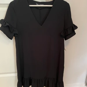 Svart kort klänning OANVÄND - Oanvänd svart klänning i storlek XS från zara. Klänningen har detaljer vid ärmarna och nertill. Jätte gullig klänning. 