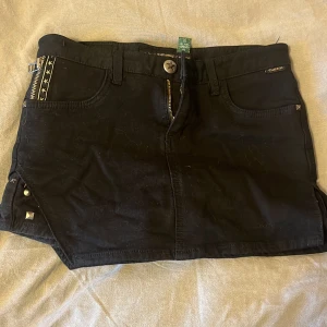 kjol - supercool svart kjol med guldiga nitar och stjärnor. Har inbygda sjorts.