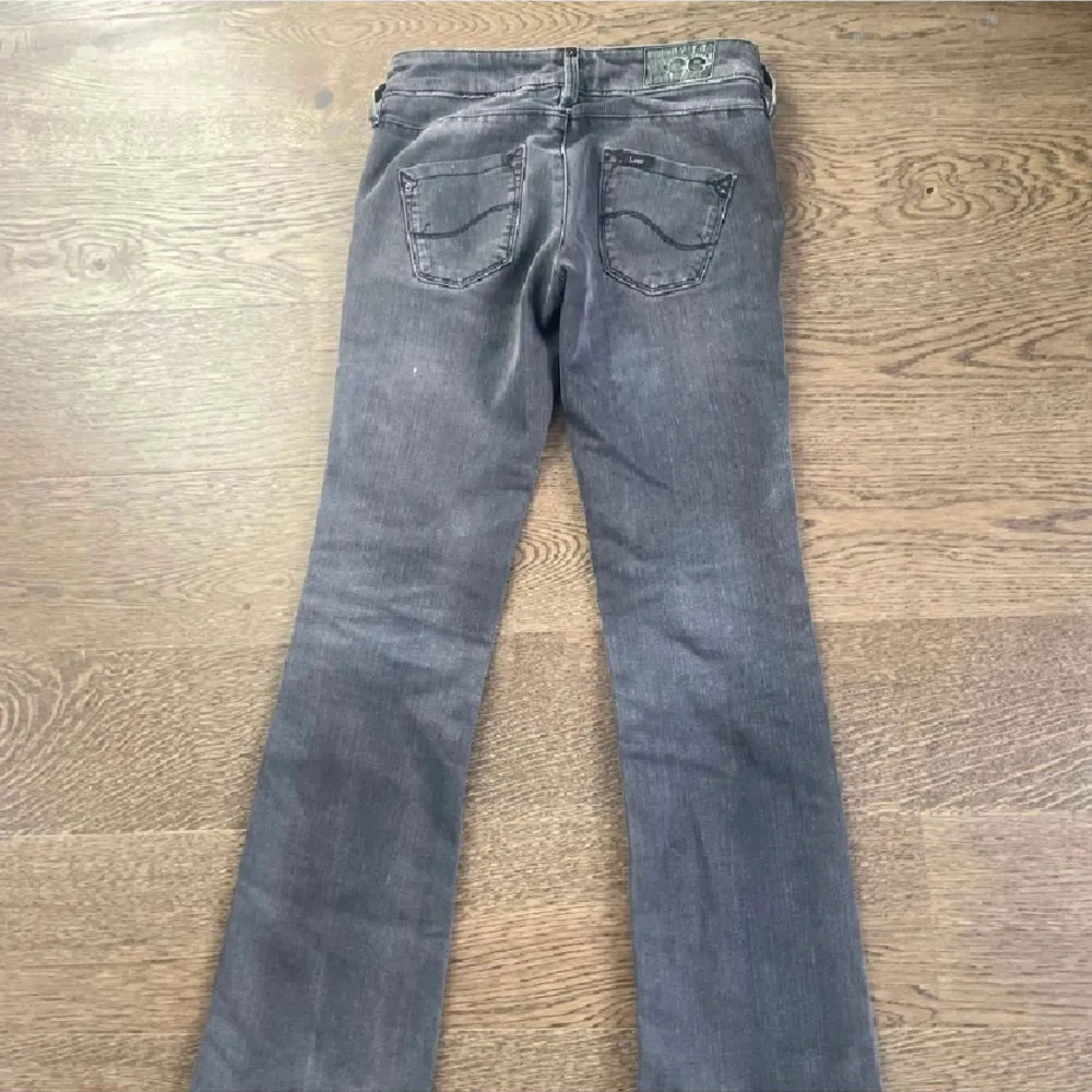 Säljer dessa jättefina lågmidjade, bootcut gråa jeans ifrån lee! Midjemåttet är ca70cm innerbennslängden är ca78. Jeansen är uppsydda lite som enkelt går att sprätta upp för att göra de längre! har inga fler bilder med jeansen på!❤️. Jeans & Byxor.