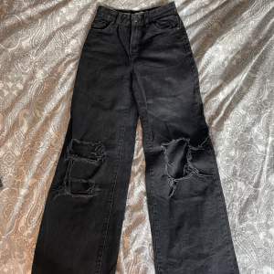 Svarta jeans med hål och vida ben, små slitningar längst ner på baksidan (se bild 3)