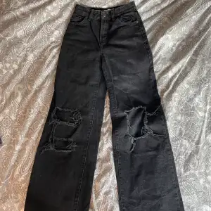 Svarta jeans med hål och vida ben, små slitningar längst ner på baksidan (se bild 3)