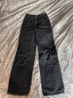 ”THE 90’S” Jeans  - Svarta jeans med hål och vida ben, små slitningar längst ner på baksidan (se bild 3)