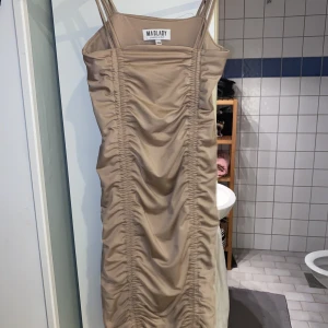 Beige klänning - Beige klänning som e skrynklad 